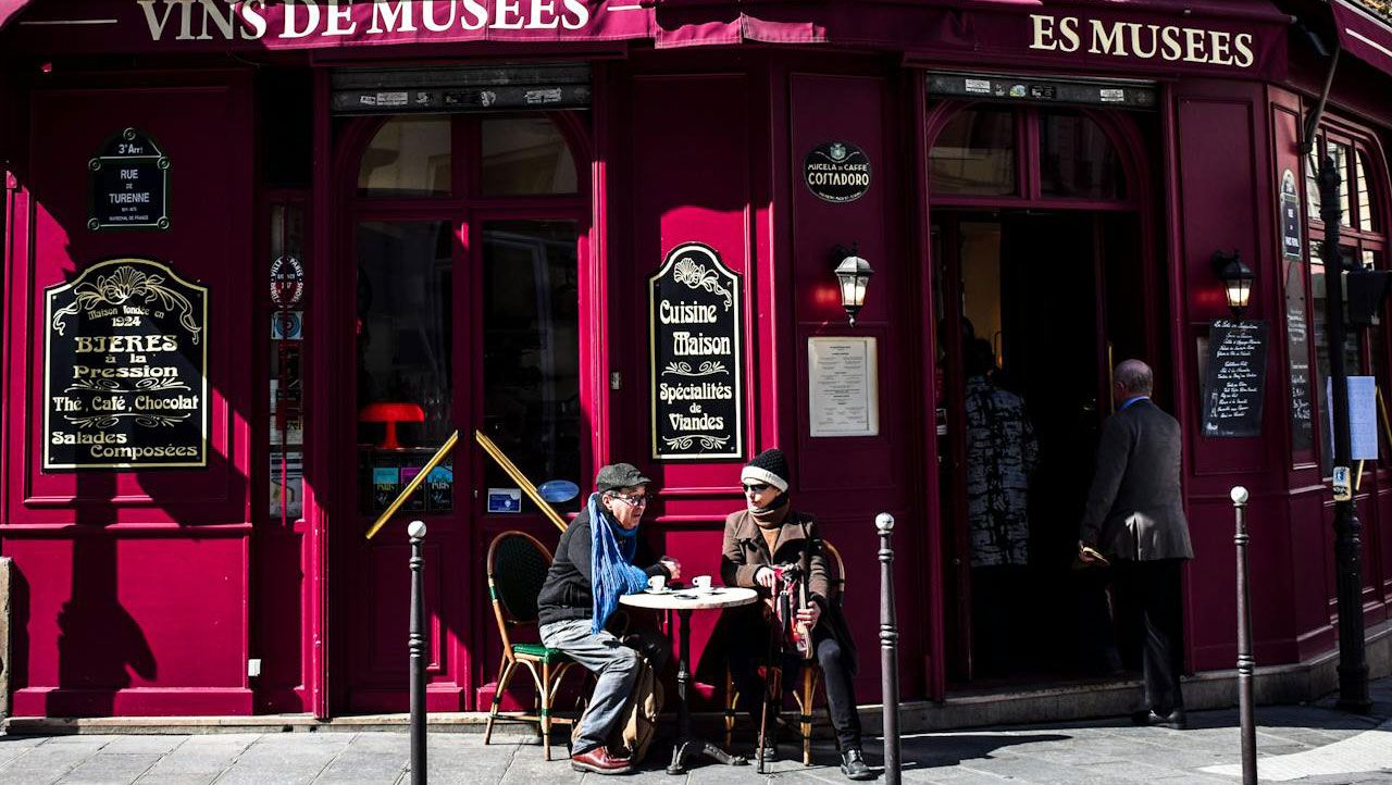 Два человека сидят в кафе в Париже Два человека сидят в кафе в Париже