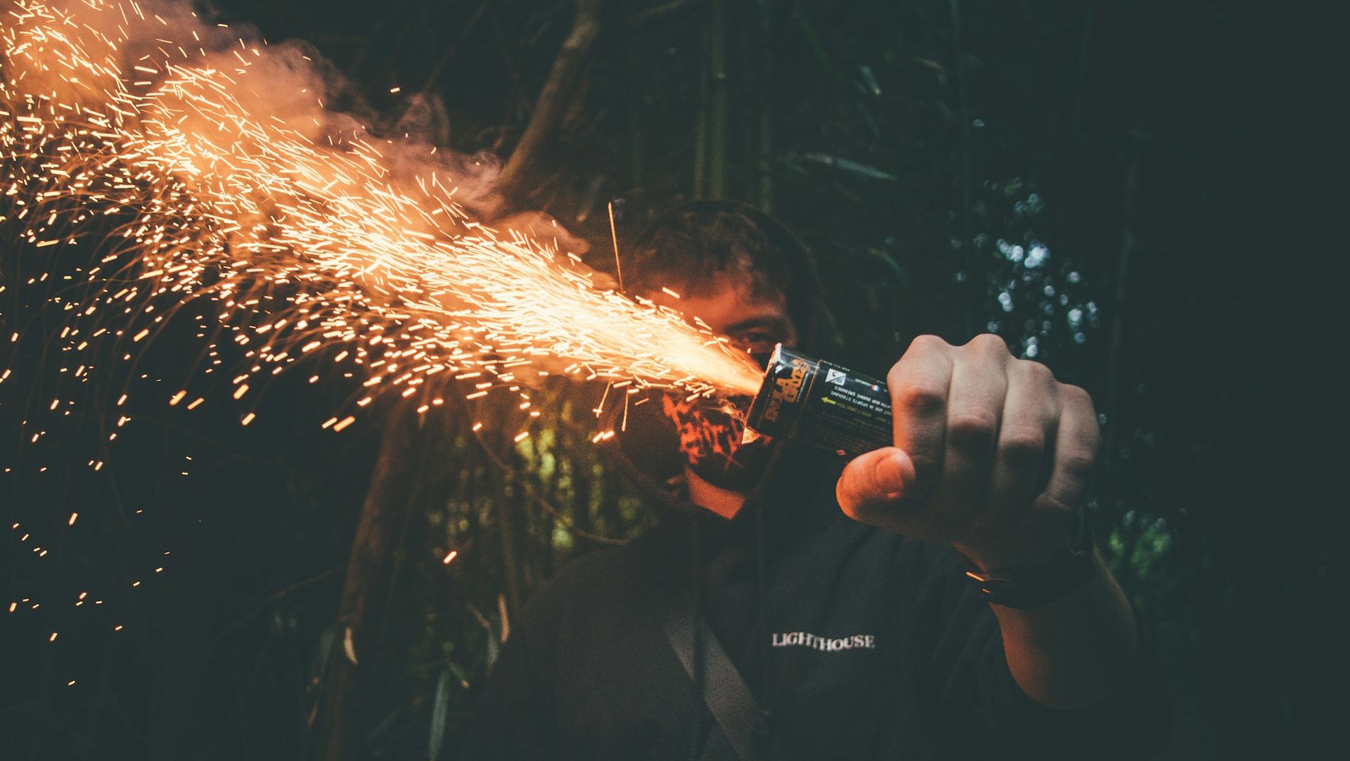 Мужчина держит фейерверк Мужчина держит фейерверк