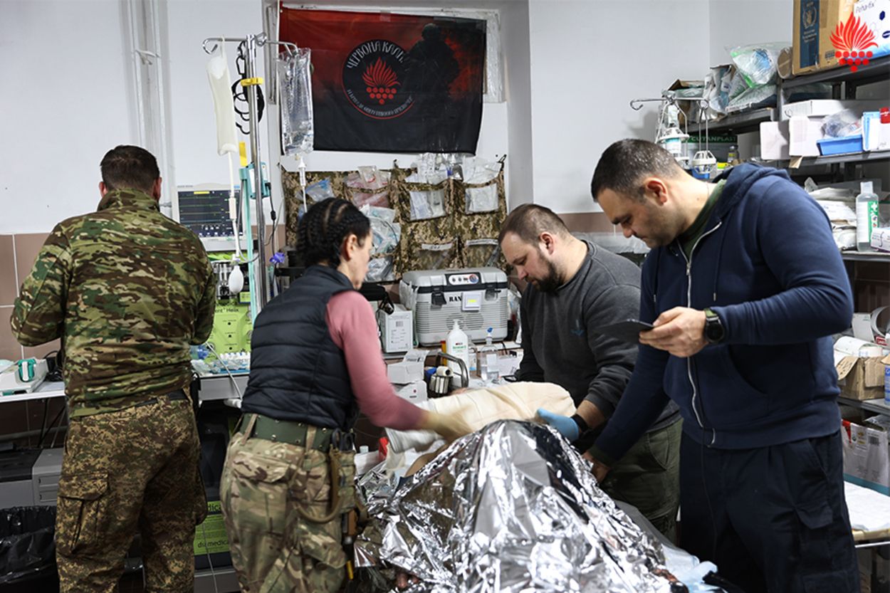 Лікарі стабпункту надають допомогу пораненому Лікарі стабпункту надають допомогу пораненому