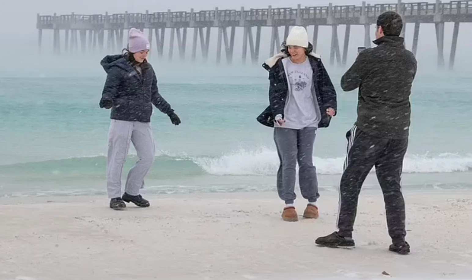 Люди на пляже Пенсакола во Флориде, когда надвигается снежная буря