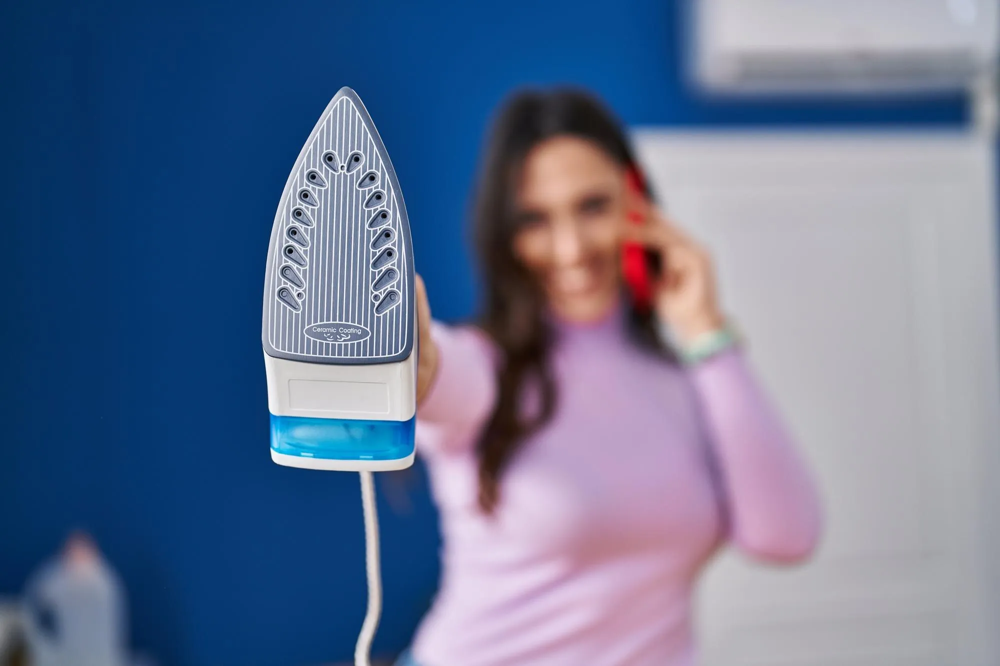 Дівчина тримає праску у руках Дівчина тримає праску у руках