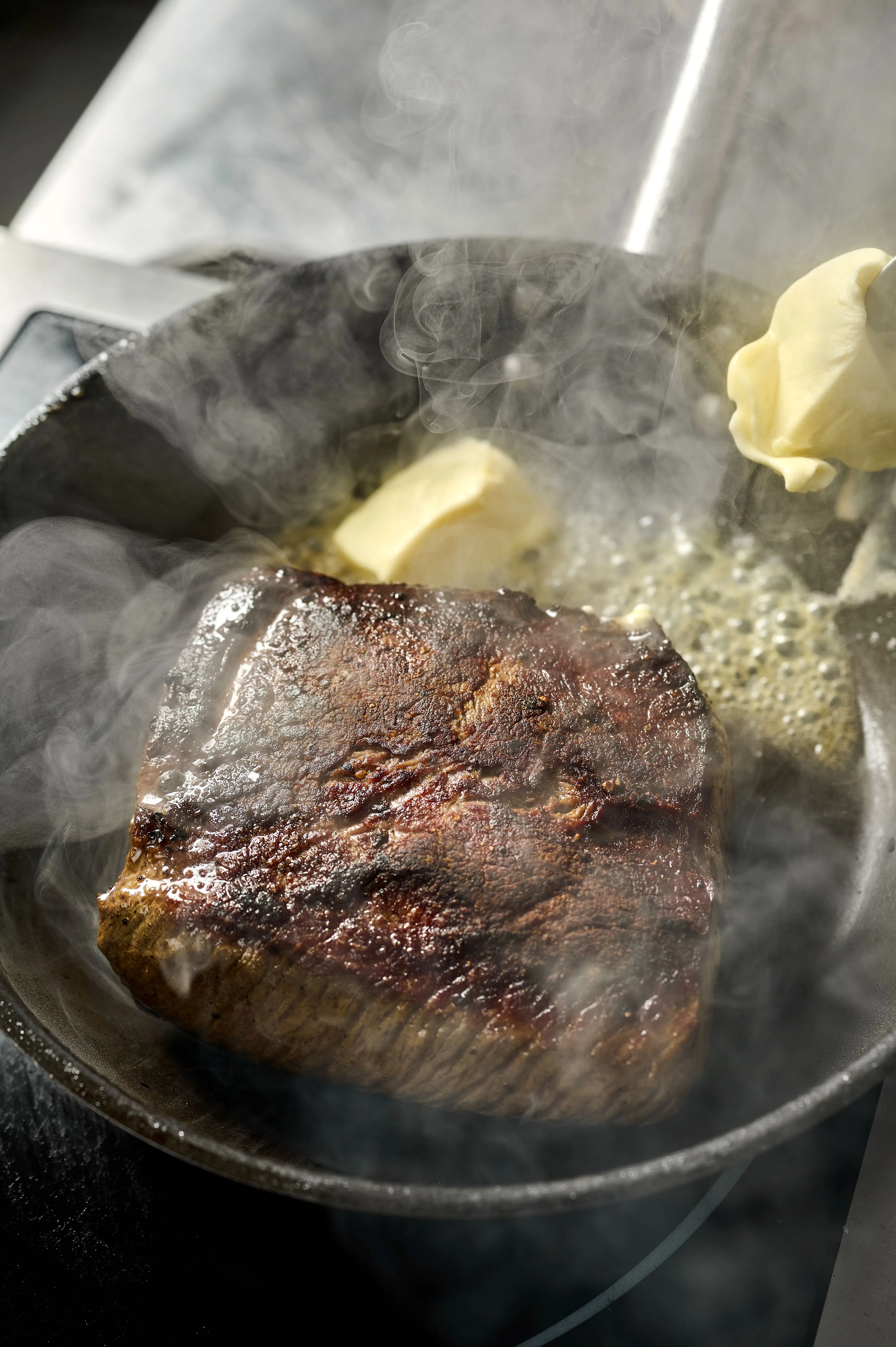 Стейк готується на сковороді Стейк готується на сковороді