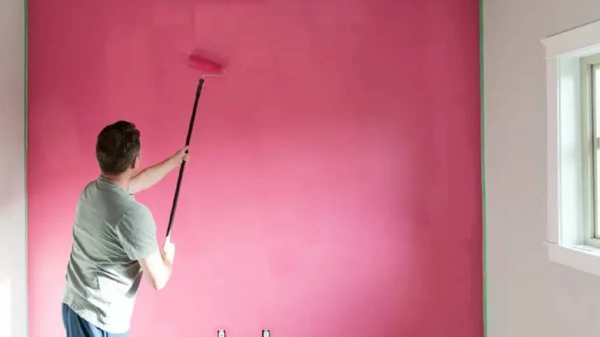 Чоловік фарбує стіну