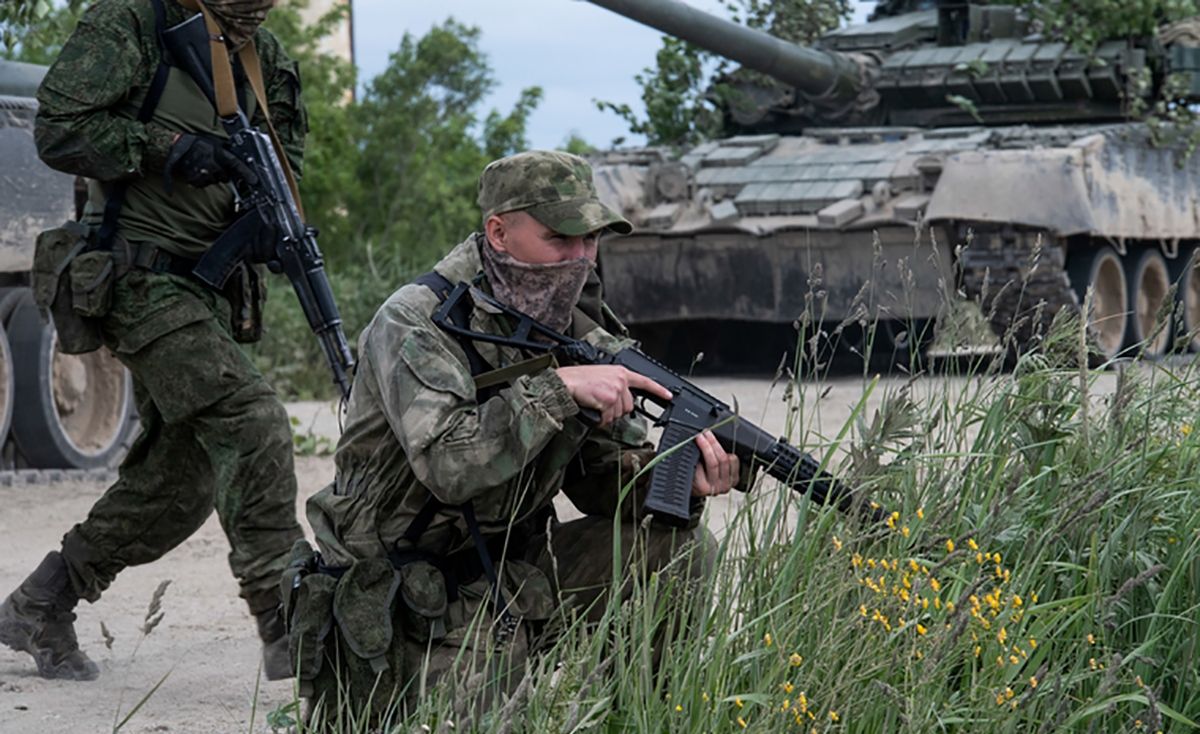 Российские оккупанты с оружием в руках Российские оккупанты с оружием в руках