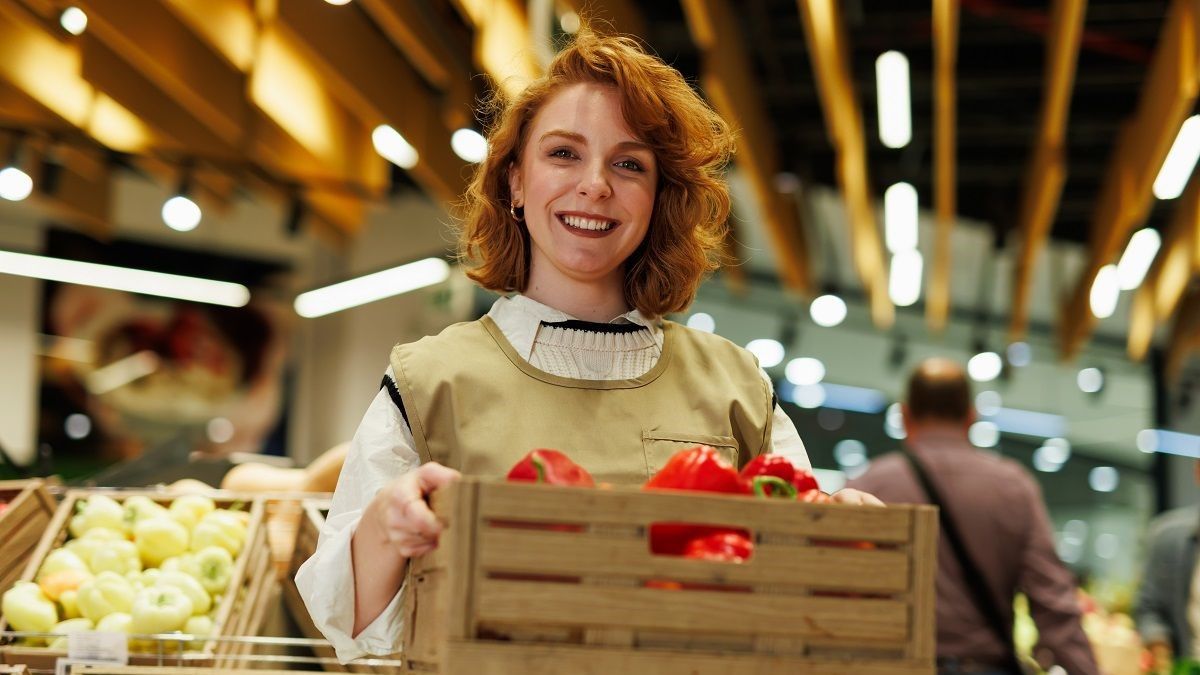 Дівчина тримає ящик з фруктами