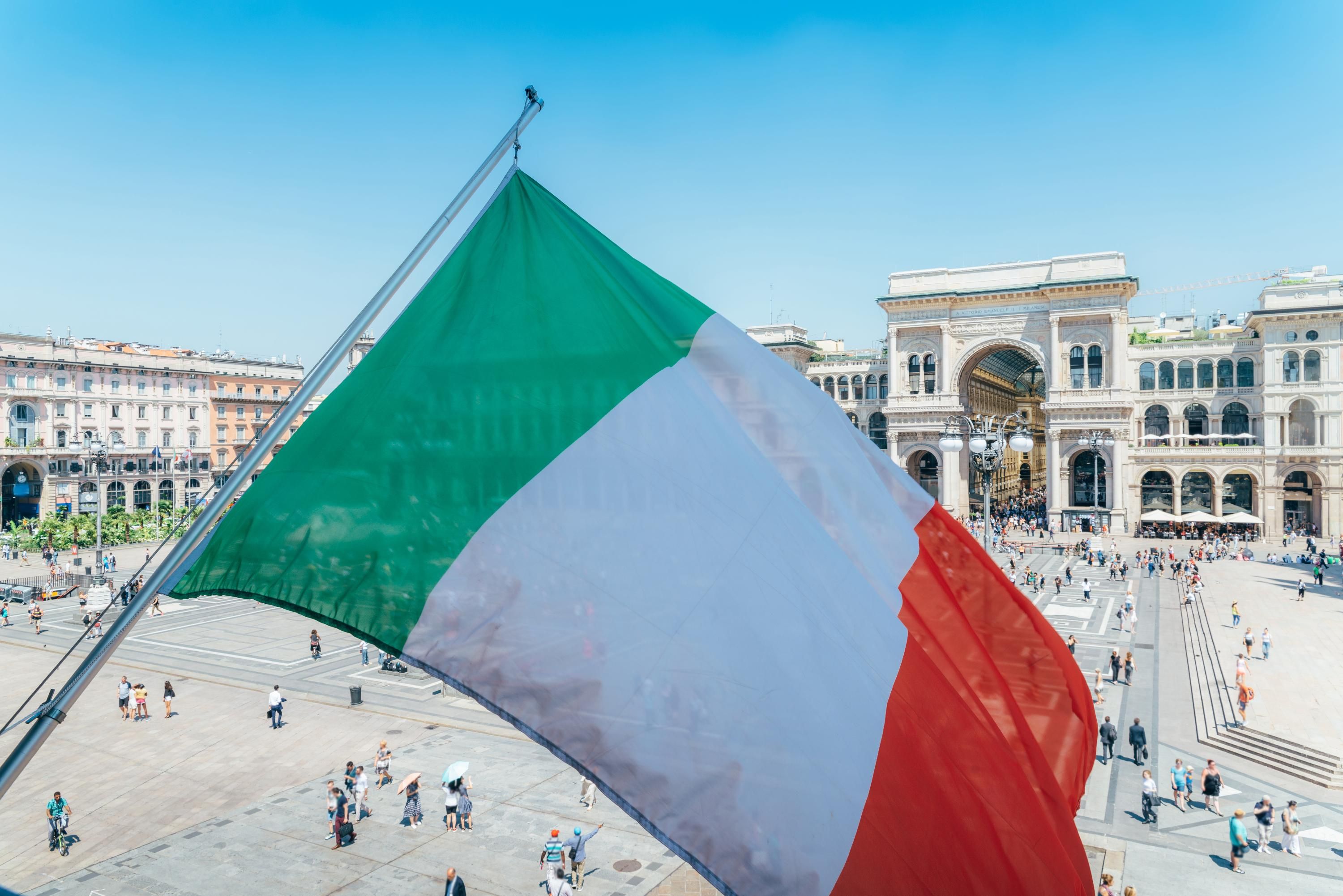 Памятник Виктору Эммануэлю II в Милане на фоне итальянского флага Памятник Виктору Эммануэлю II в Милане на фоне итальянского флага