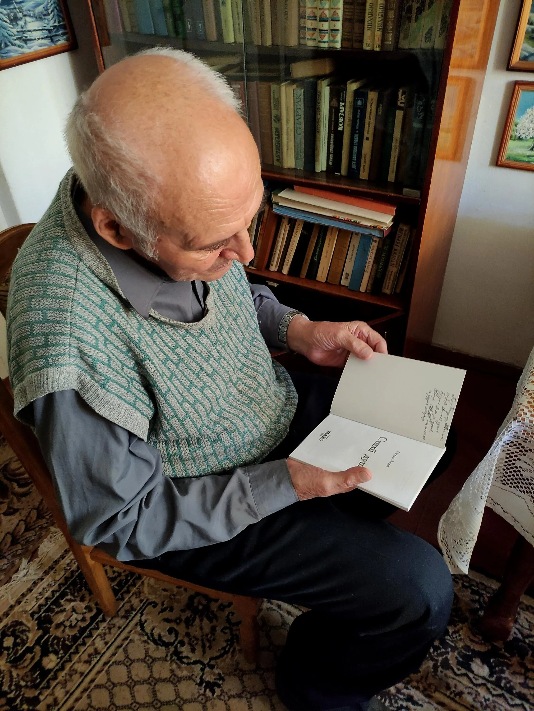 Пан Богдан показує одну з книг своєї бібліотеки