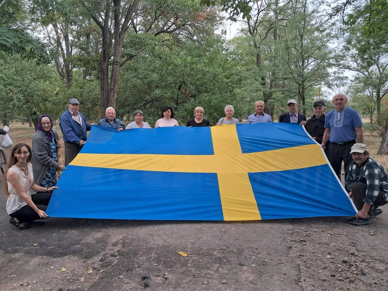 Люди тримають прапор Швеції Люди тримають прапор Швеції
