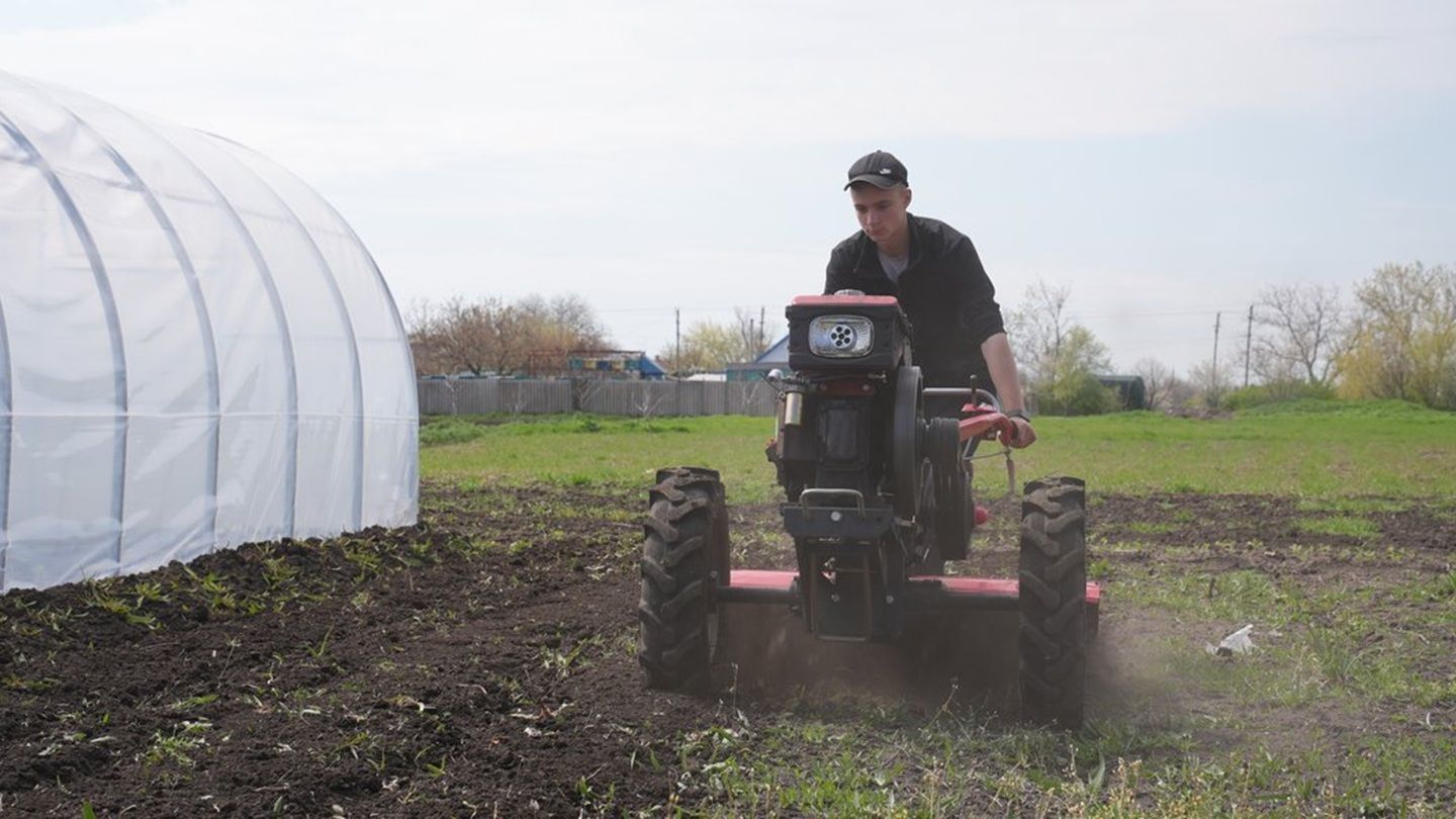 Підліток обробляє землю
