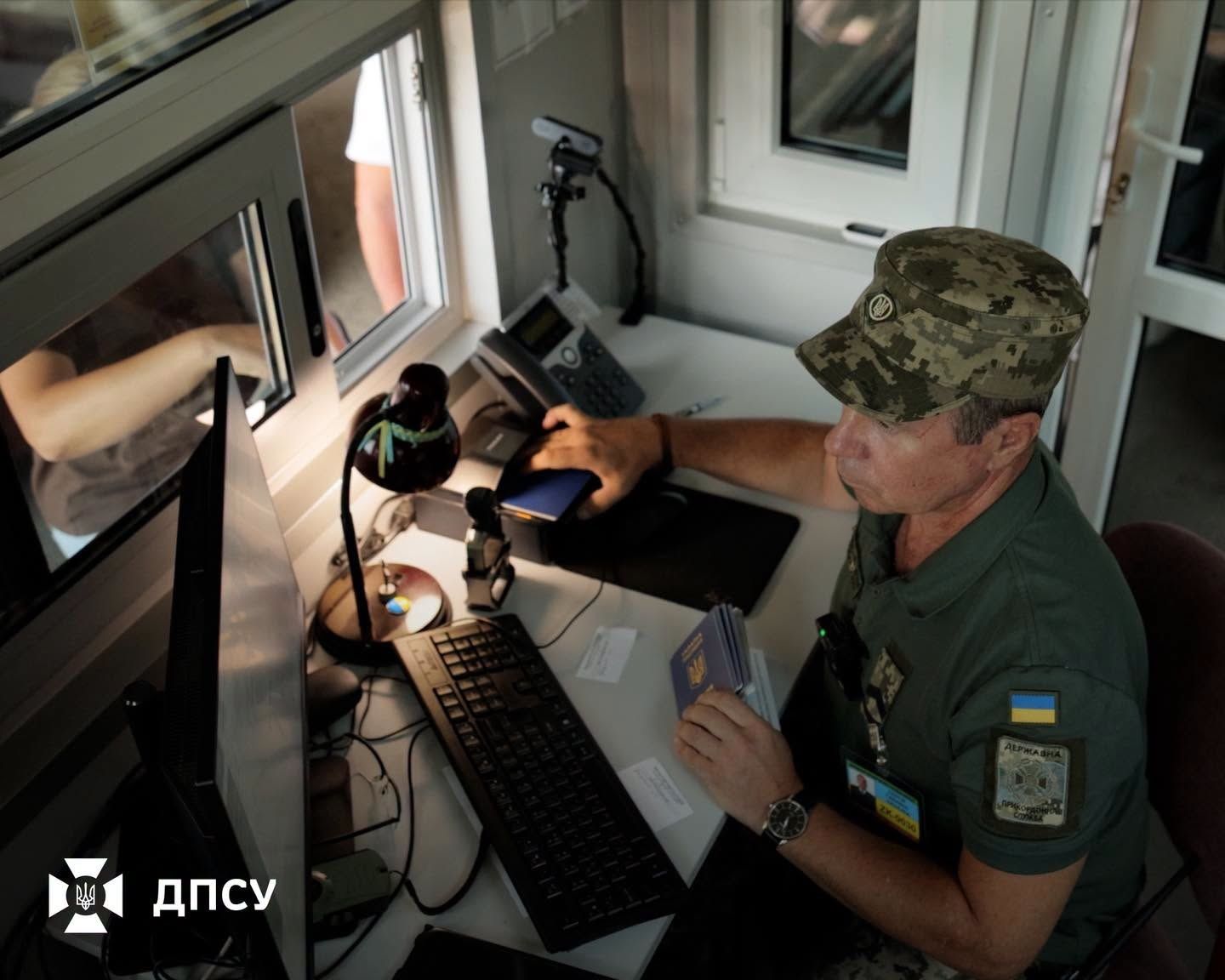 Співробітник ДПСУ перевіряє документи на пропускному пункті Співробітник ДПСУ перевіряє документи на пропускному пункті