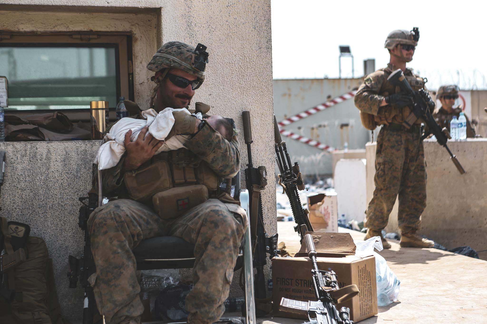 Американський військовий заколисує афганське немовля