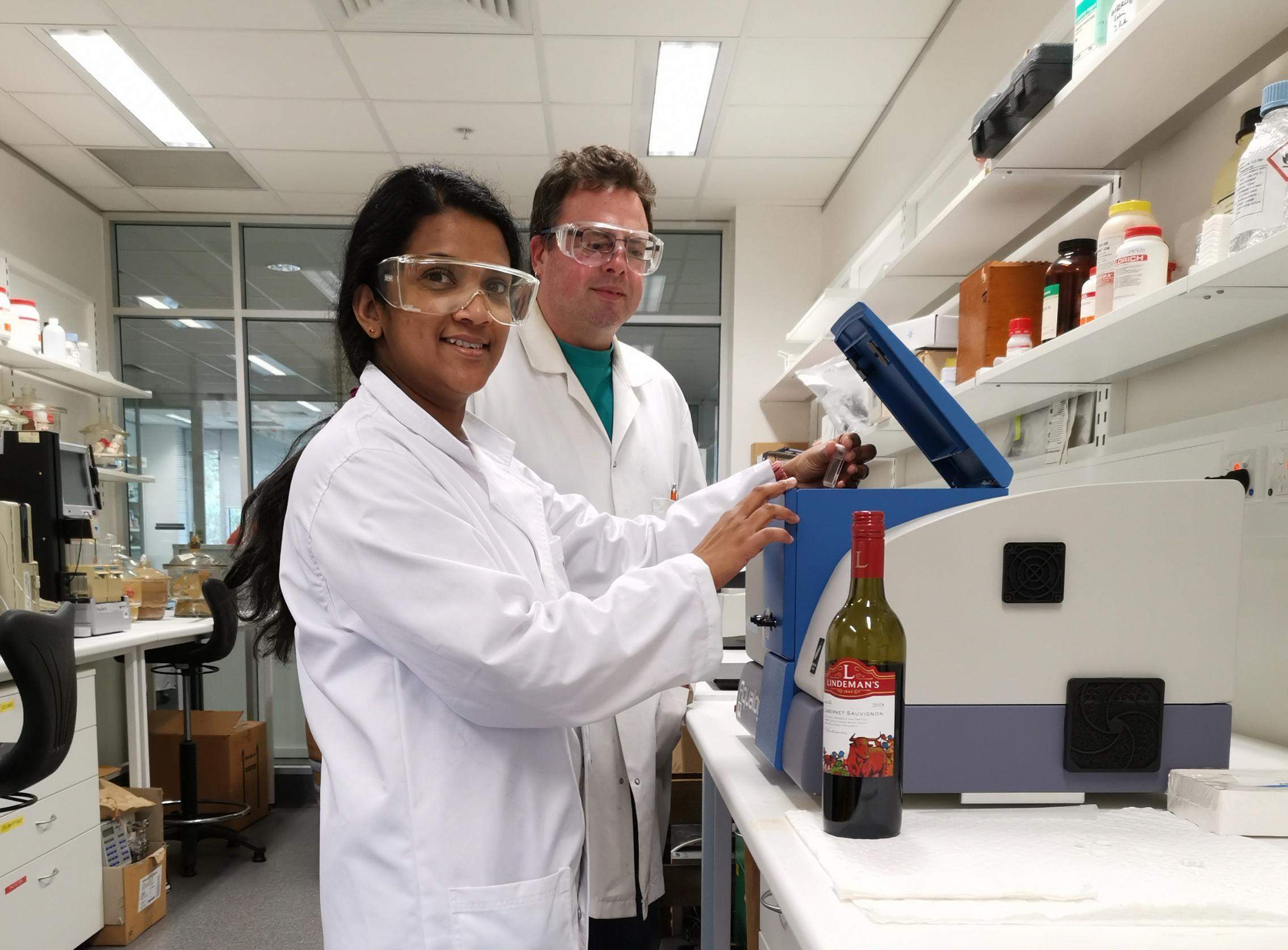 Аспірантка Ручіра Ранавеера завантажує зразок вина в спектрофлуорометр разом із доцентом Девідом Джеффері