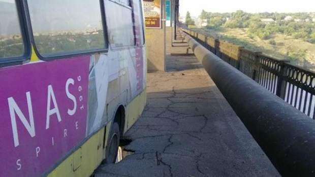 Автобус застряг у наскрізній дірці