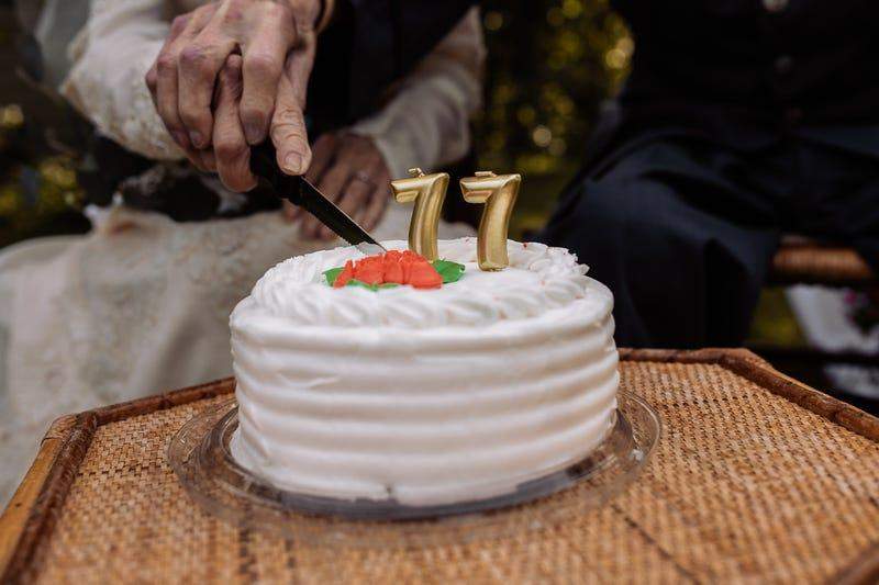 Пожилая супружеская пара торжественно разрезала свадебный торт